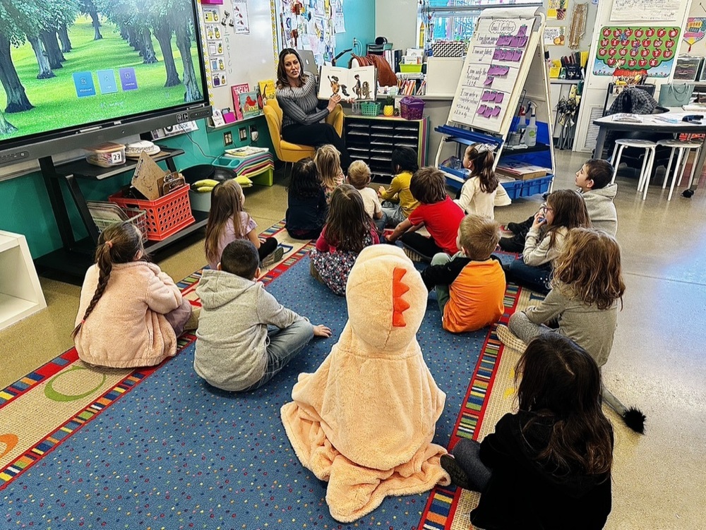 Dani Barkey reading to a kindergarten class sitting on the floor
