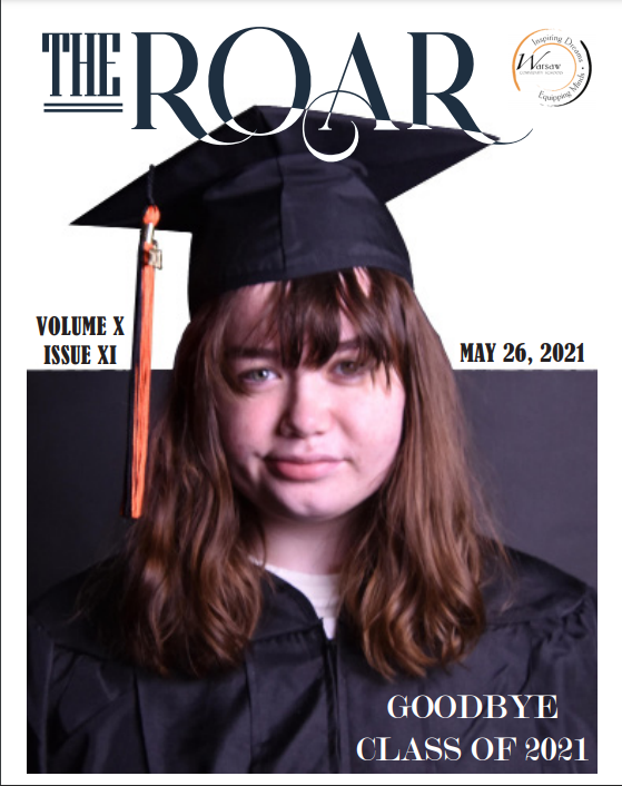 A 2021 Senior is posing in her cap and gown